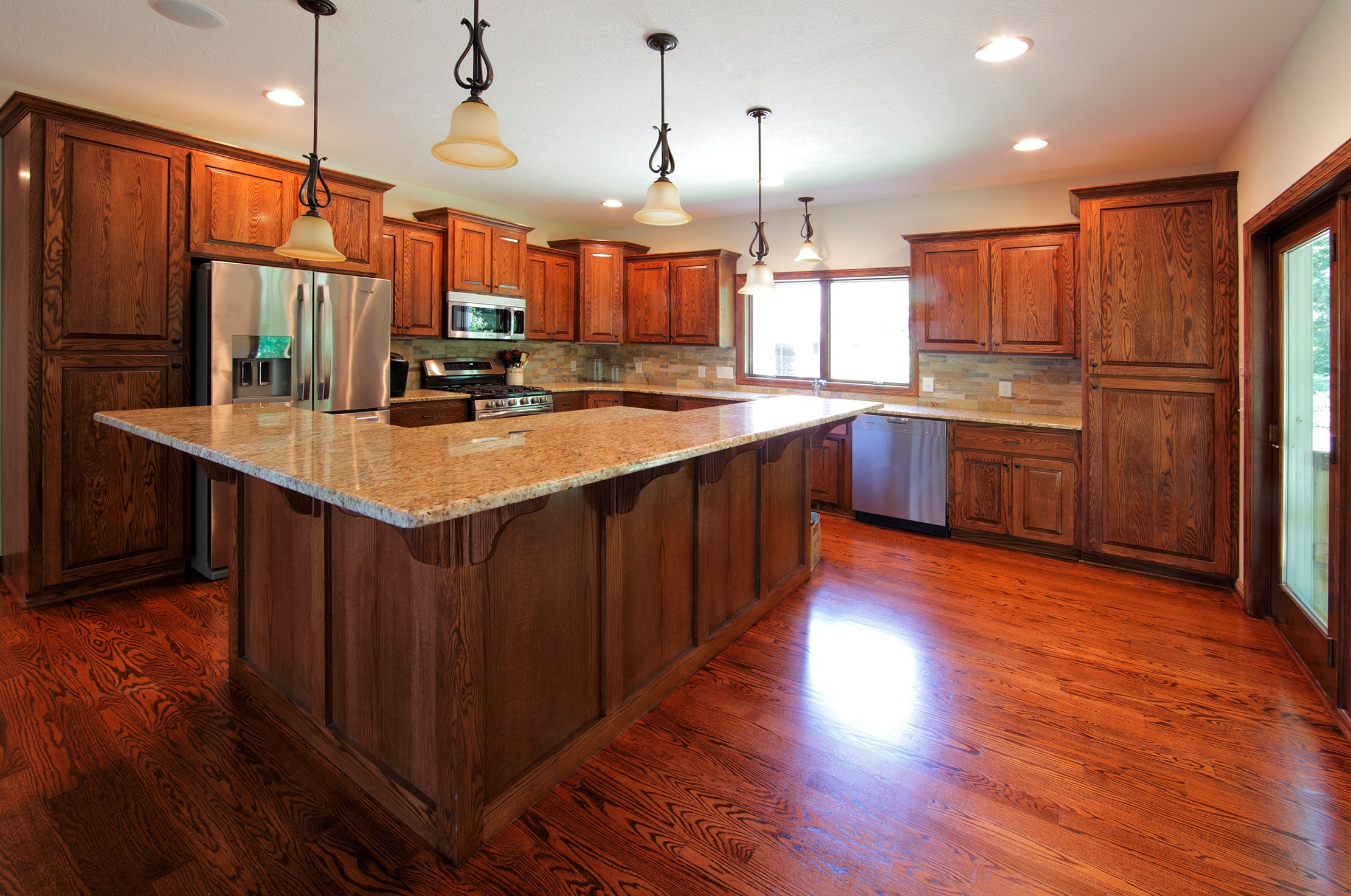 Spacious oak kitchen with large island and pendant lights